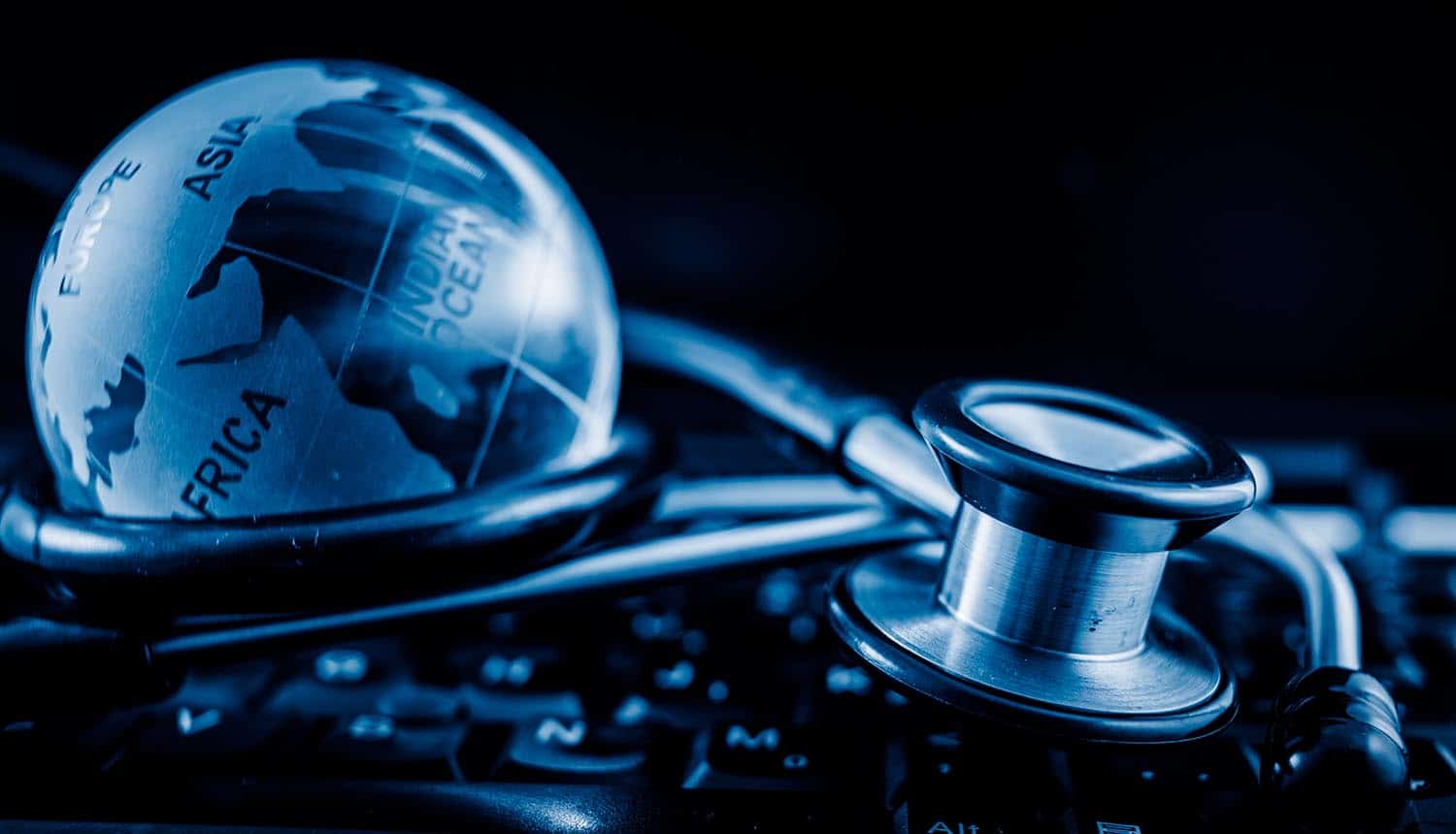 Glass globe and stethoscope on a computer keyboard showing health websites sharing medical data with advertisers