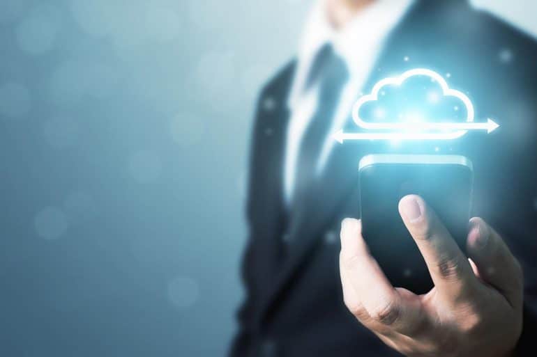 Businessman holding mobile smart phone communicating with cloud server showing how to secure cloud apps with DevOps