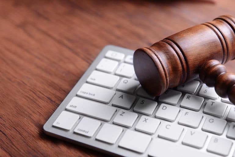 Wooden gavel and keyboard on desk showing the steps to take in anticipation of CCPA litigation in 2020