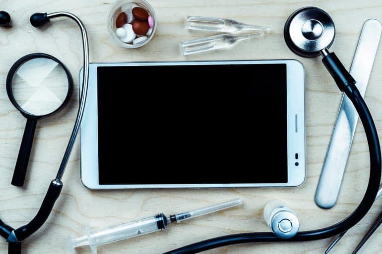 Tablet with medical equipment showing LifeLabs data breach being the largest ever in Canada and may cost the company over $1 billion in lawsuit