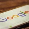 Google logo on smartphone showing the open letter from major NGOs asking Google to cut pre-installed apps that enable data exploitation