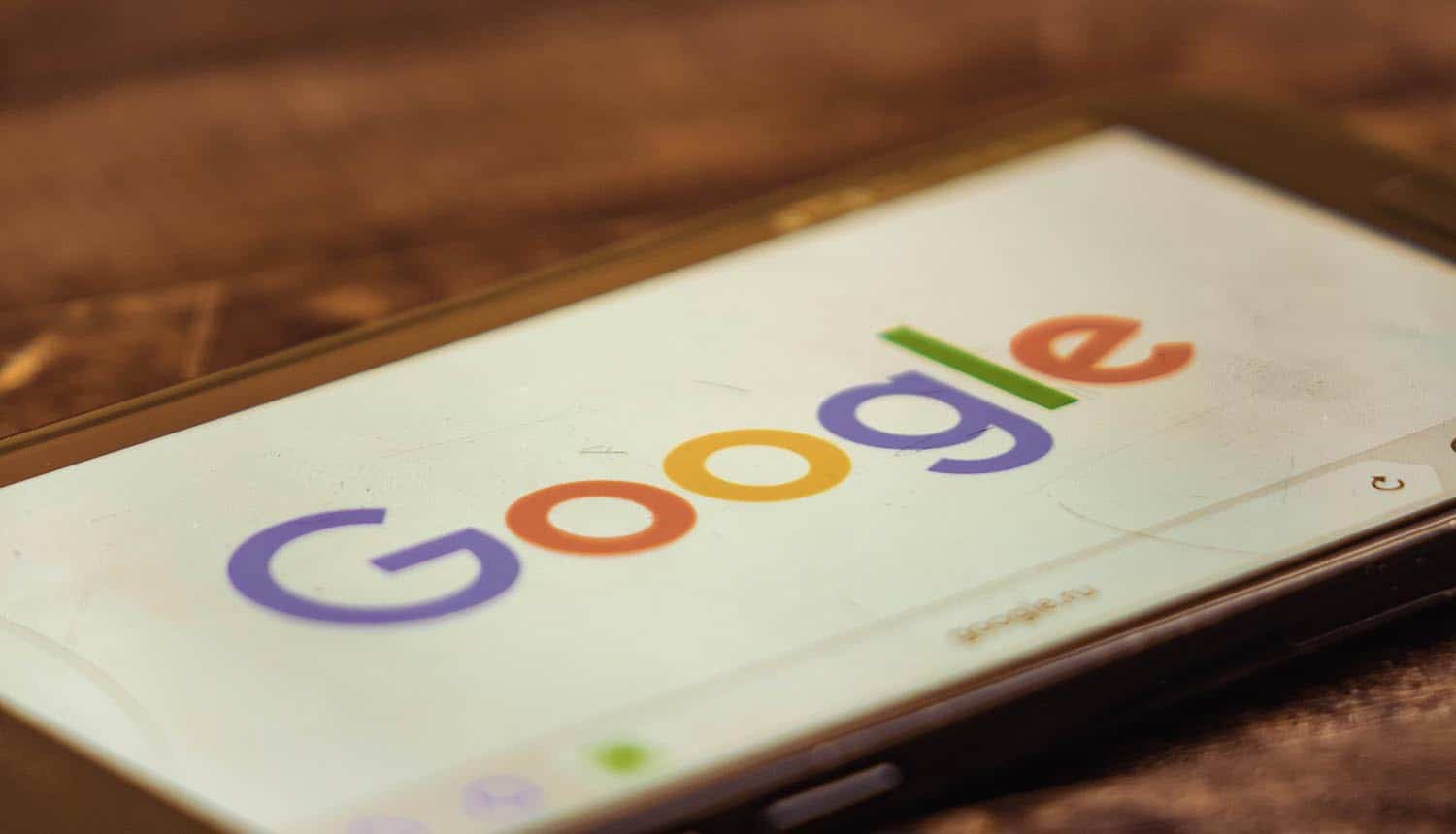 Google logo on smartphone showing the open letter from major NGOs asking Google to cut pre-installed apps that enable data exploitation