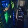 Hooded hacker working with laptop in dark data center showing the dangers of insider threats