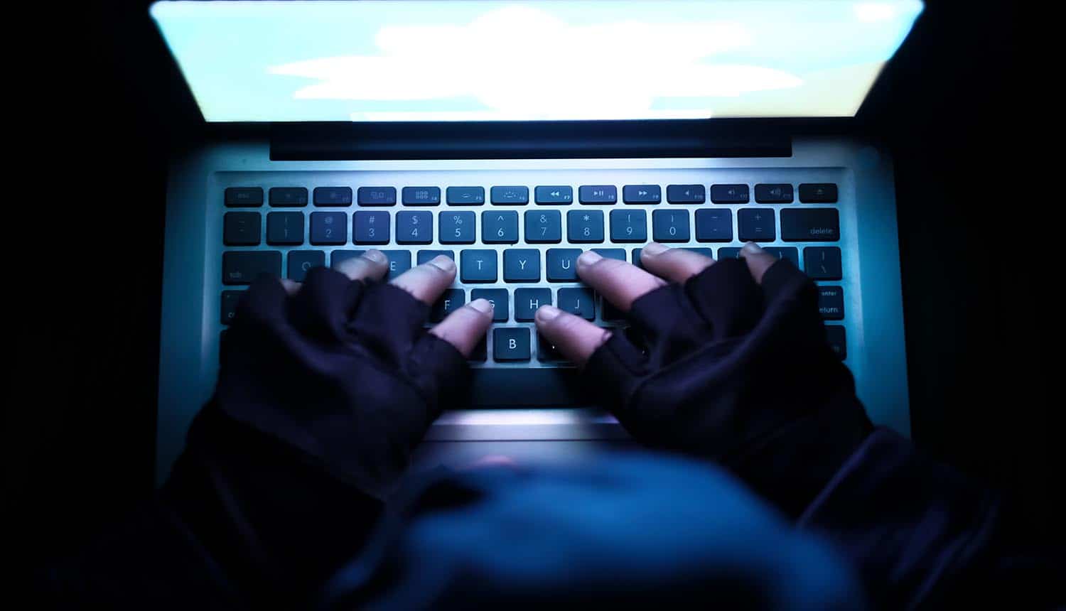 Hacker using laptop showing China’s public accusation on CIA of 11 years of cyber espionage