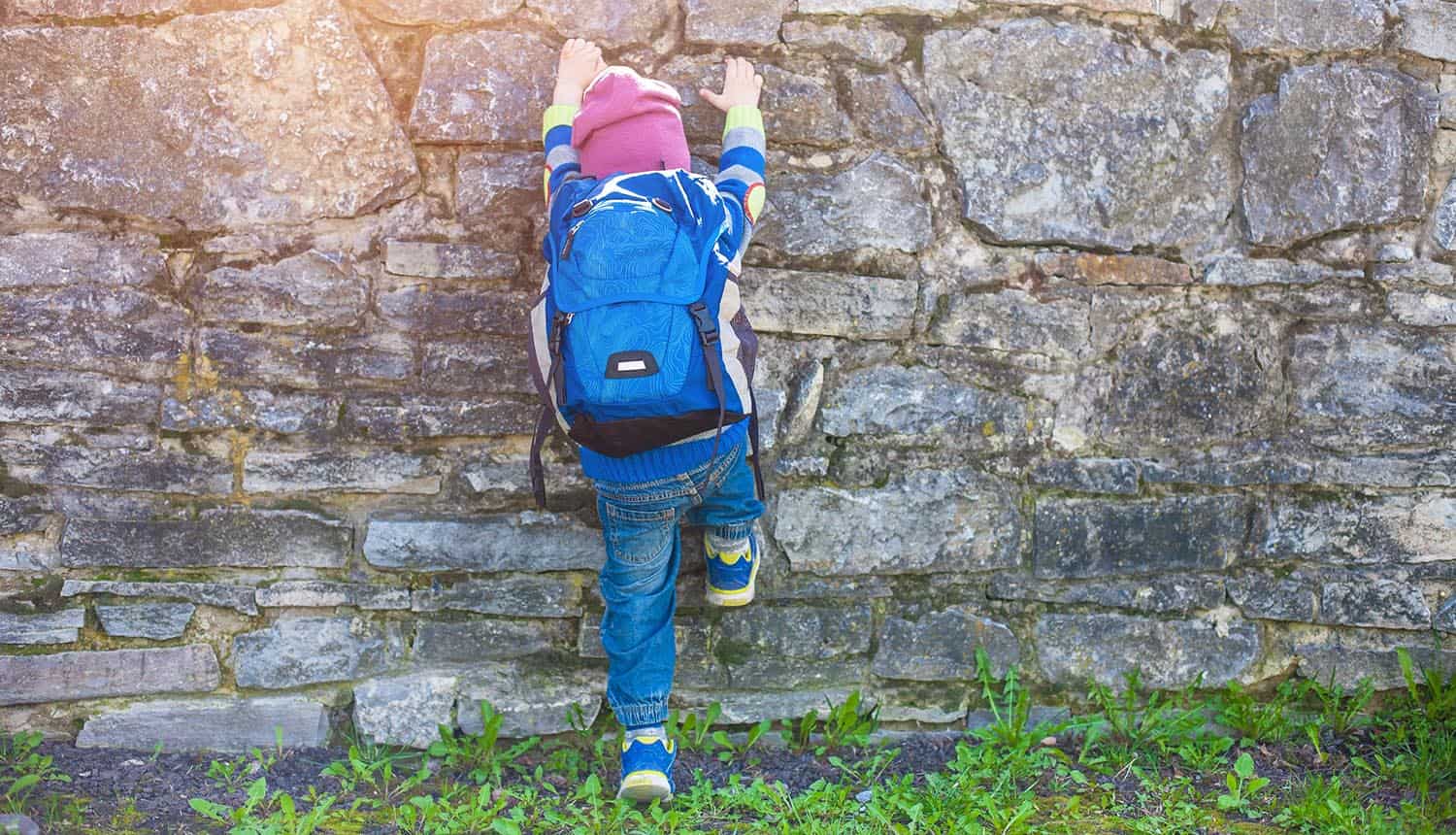 Child climbing on a stone fence showing the digital divide exposed in U.S. pandemic response