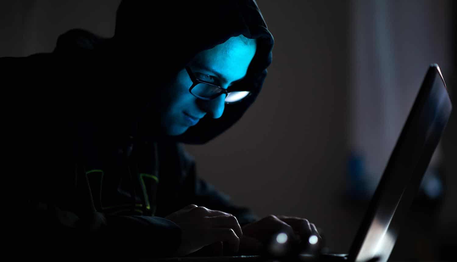 Hacker stealing information with laptop showing Ryuk ransomware still active during the coronavirus pandemic
