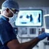 Healthcare worker working on machine showing the warning from cybersecurity agencies on APT groups running cyberattacks to get COVID-19 research data