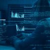 Hacker working on machine showing stolen data sold on dark web by hacking group