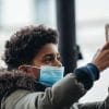 Boy in mask using mobile showing the proposed U.S. Exposure Notification Privacy Act that could control the potential misuse of contact tracing apps