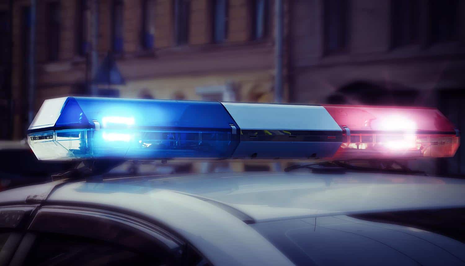 Red and blue signal lights on the roof of a police patrol car showing law enforcement purchase of breach data