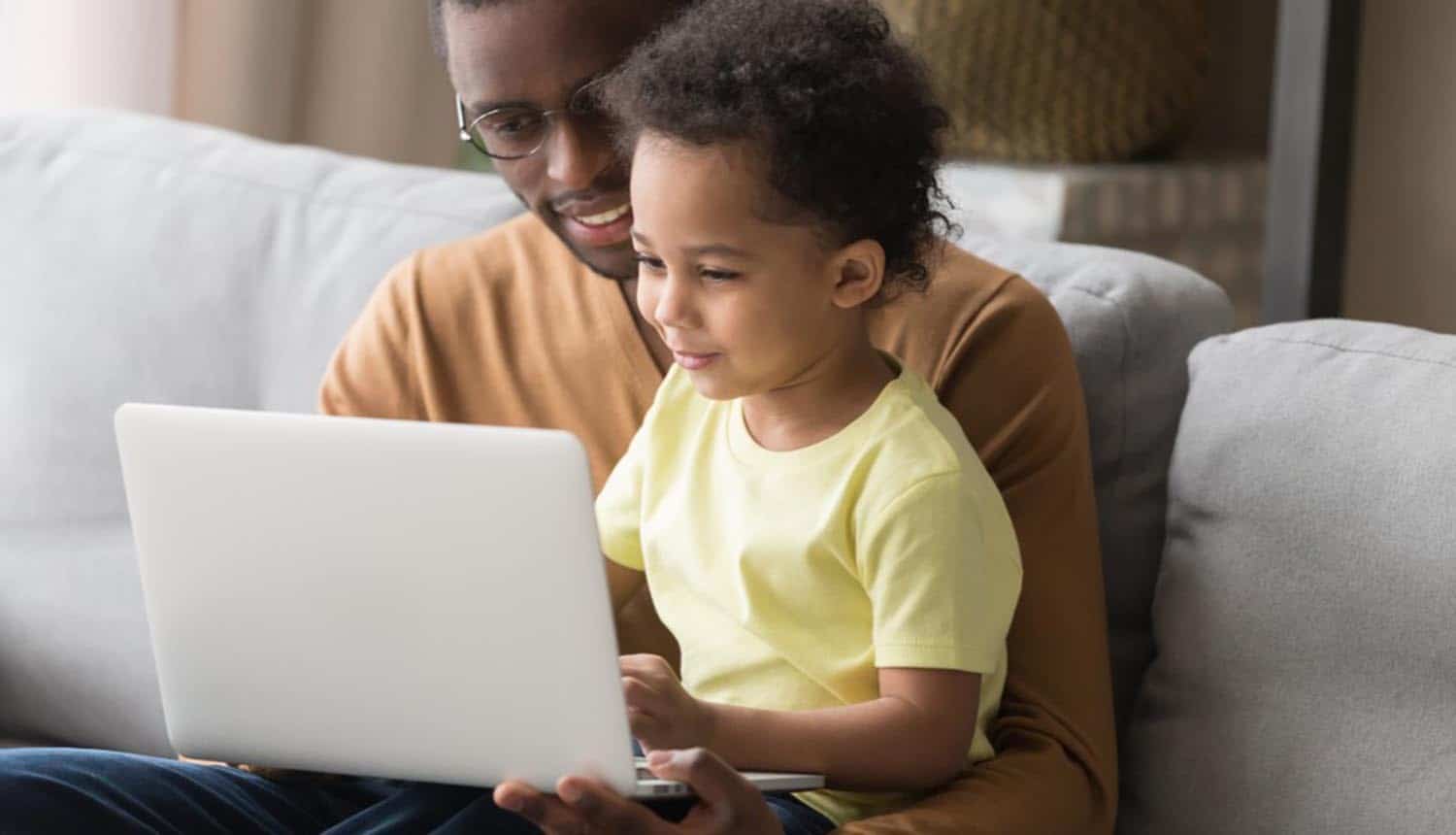 Father and child in front of laptop showing ways to stay safe online