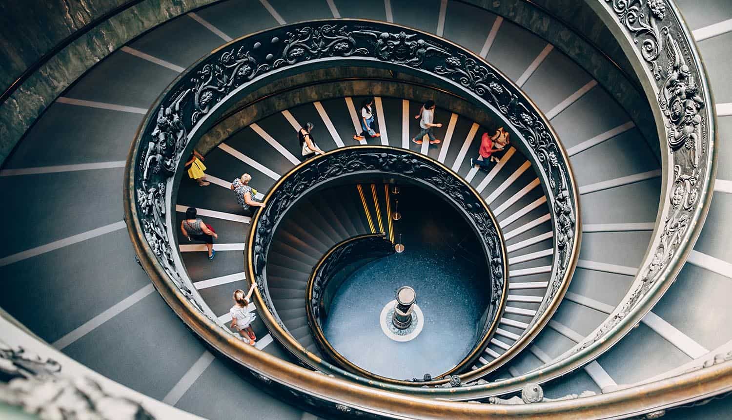 People climbing down the spiral stairs of the Vatican Museums showing threat of Chinese hackers