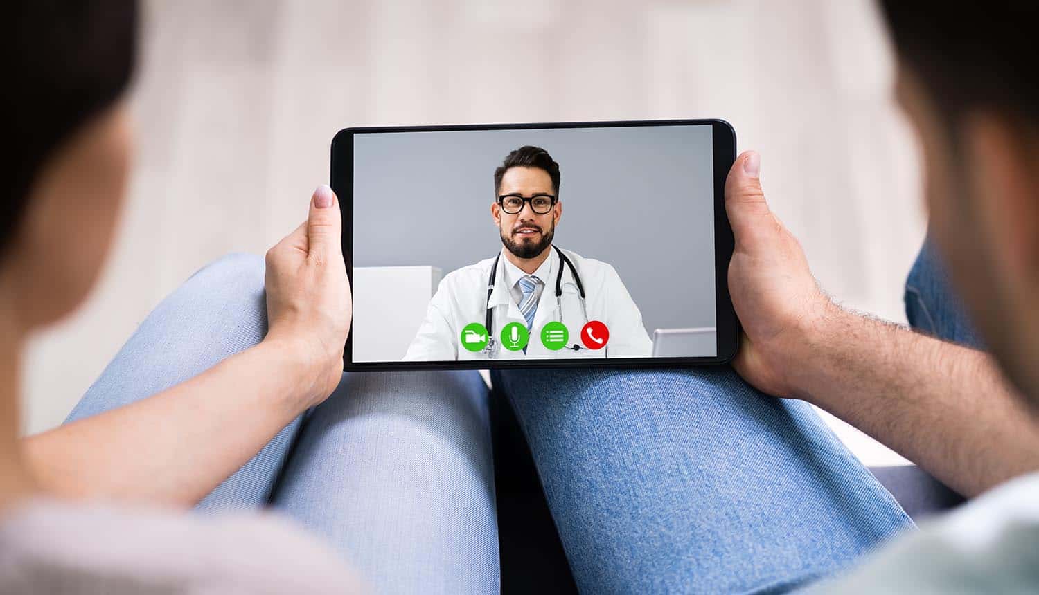 Couple using telehealth services in video conference call with doctor showing increased cyber threats