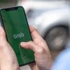 Man using Grab app on smartphone showing latest privacy breach