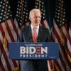 2020 election candidate Joe Biden on podium showing hacker groups targeting Trump and Biden campaigns
