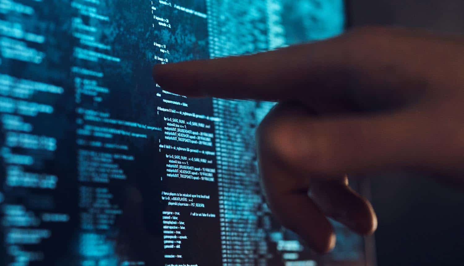 Developer pointing finger at screen with code showing need for open source for trust and security