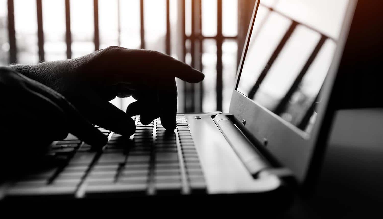 Hands typing on laptop showing insider threats
