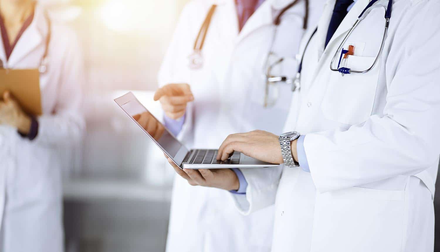 Group of doctors, with stethoscopes, using technology showing digital transformation in healthcare sector