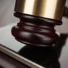 Judge gavel on a smart phone showing Facebook mulling over antitrust suit against Apple