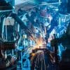 Robots welding movement in a car production factory showing IoT security and zero trust