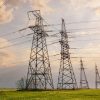 Power lines in the spring in a green wheat field showing SolarWinds backdoor in electric utilities