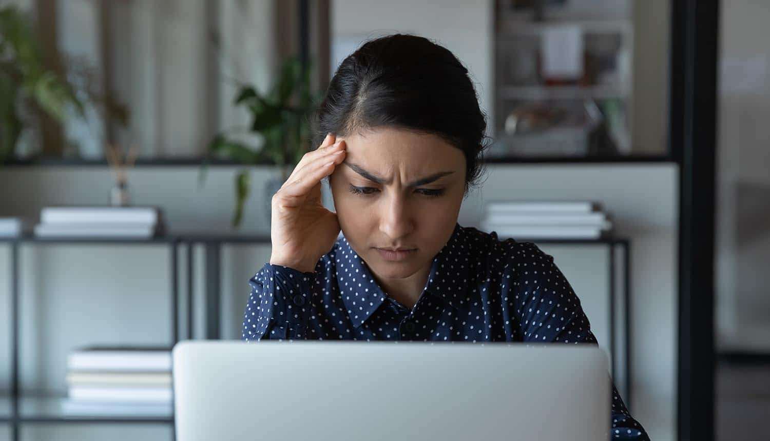 Close up stressed puzzled businesswoman looking at laptop screen showing data leak of credit scores due to API security issue