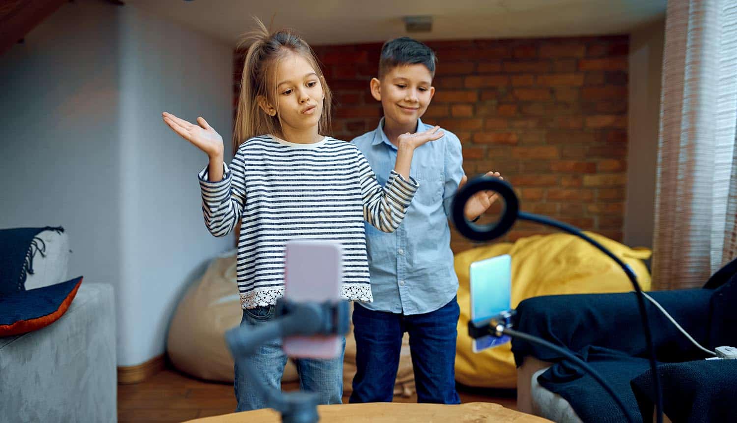 Cheerful children bloggers dance on camera showing TikTok lawsuit on child privacy