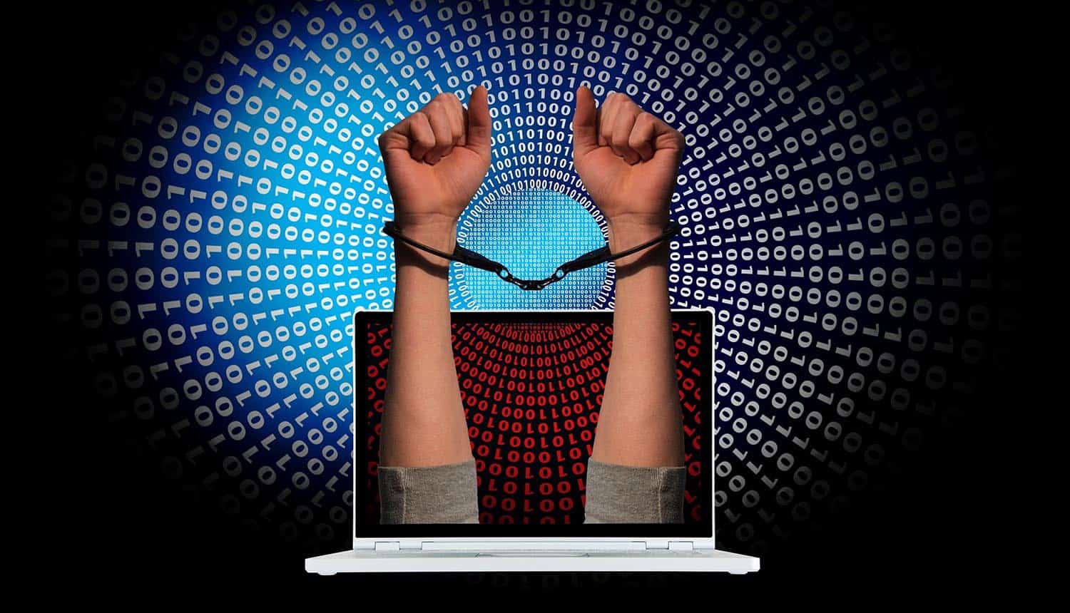 Handcuffs on arms reaching out from laptop