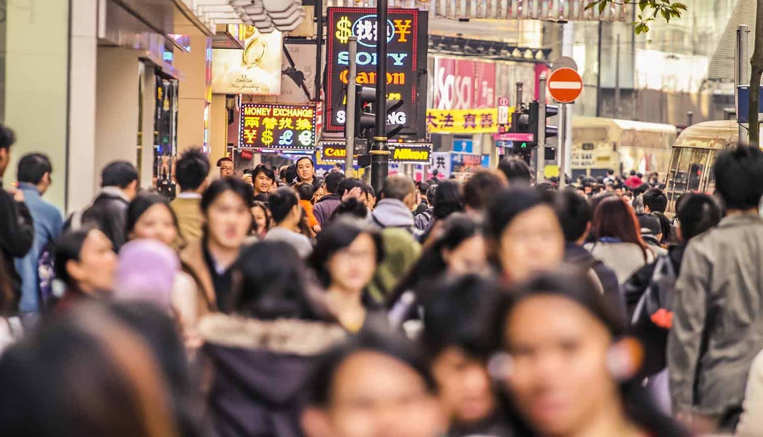 Large crowd of people walking along a sidewalk in Hong Kong showing Big Tech protest over doxxing privacy law