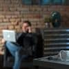 Businessman working at home leaving COVID-19 protective mask on desk showing digital risks