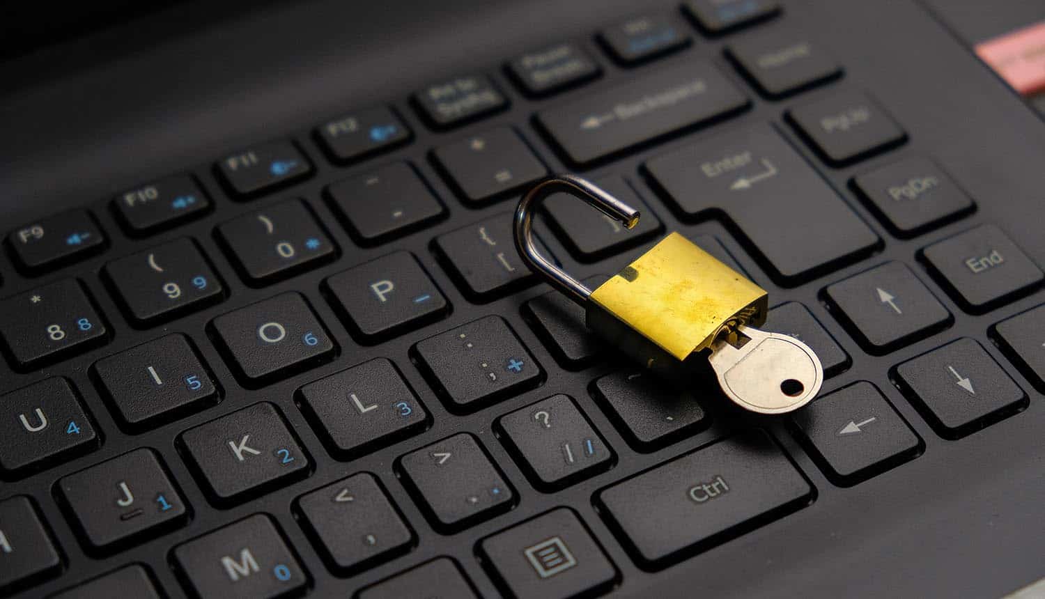 Unlocked padlock on keyboard showing decryption key for REvil ransomware