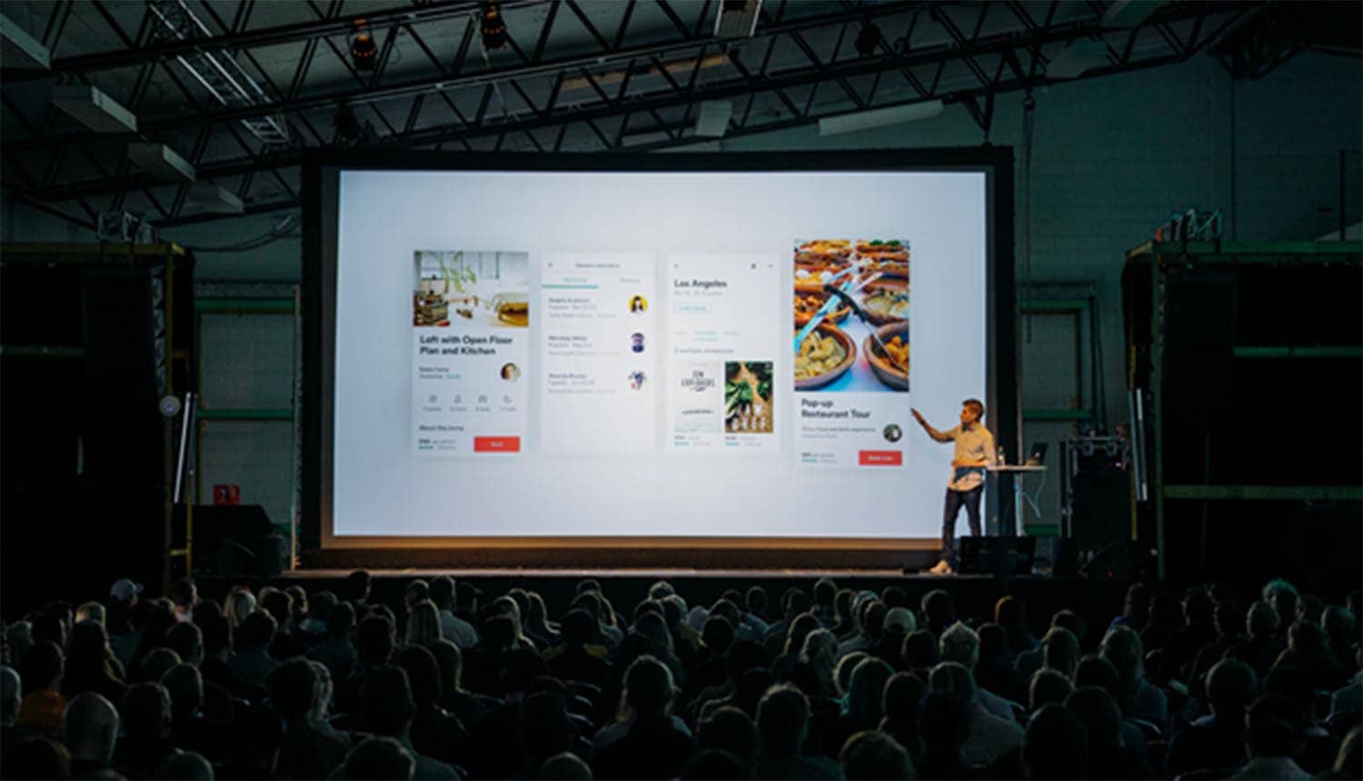 Man on stage speaking to audience