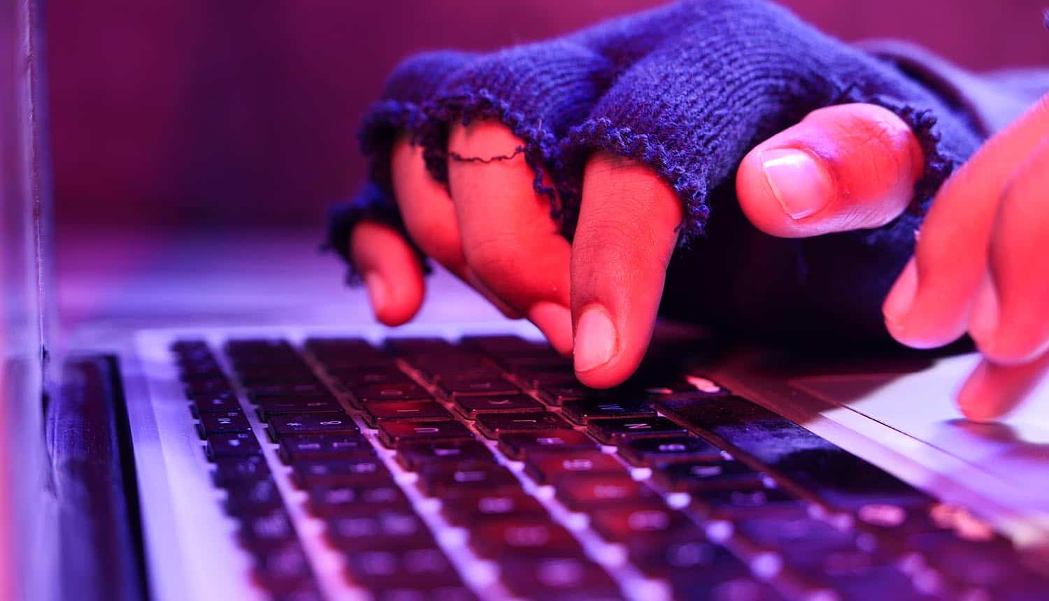 Close up of hacker hand stealing data from laptop showing ransomware attack by LockBit Ransomware gang
