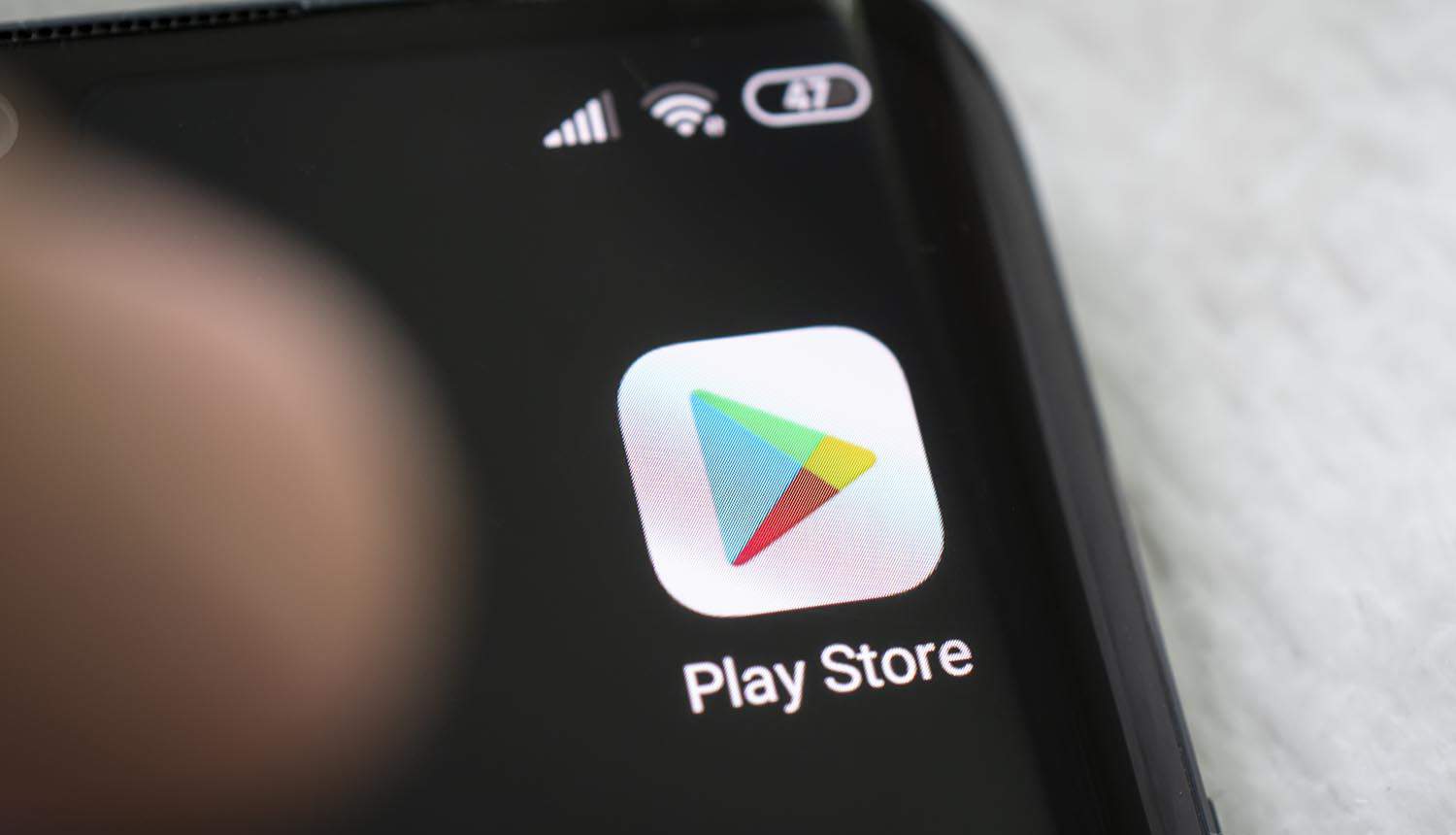 Google play store app on the screen of a black smartphone showing Android malware in scam apps