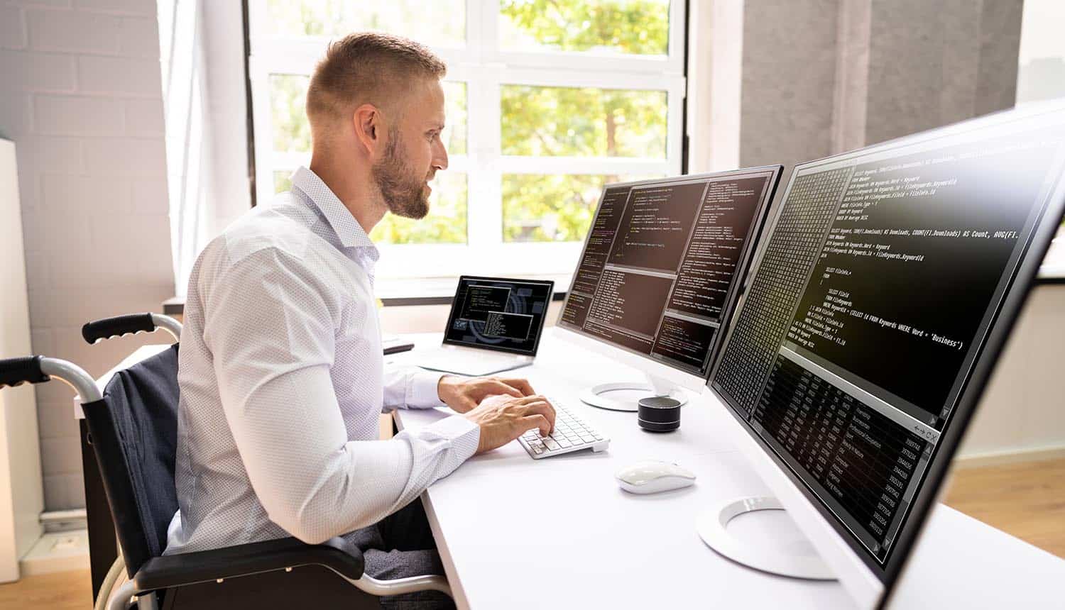 Computer programmer writing program code on computer