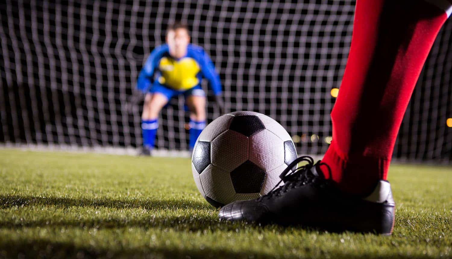 Soccer player with ball against goalkeeper standing on playing field showing GDPR question