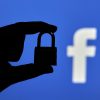 Silhouette of a person hand holding a padlock over Facebook logo showing privacy concerns over Facebook metaverse