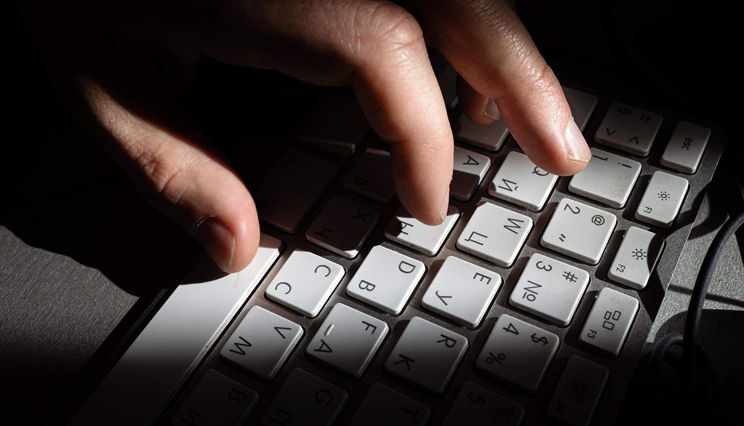 Hand and computer keyboard close up showing cyber attack on WordPress sites