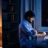 Side view of man doing remote work on computer showing compliance blueprint