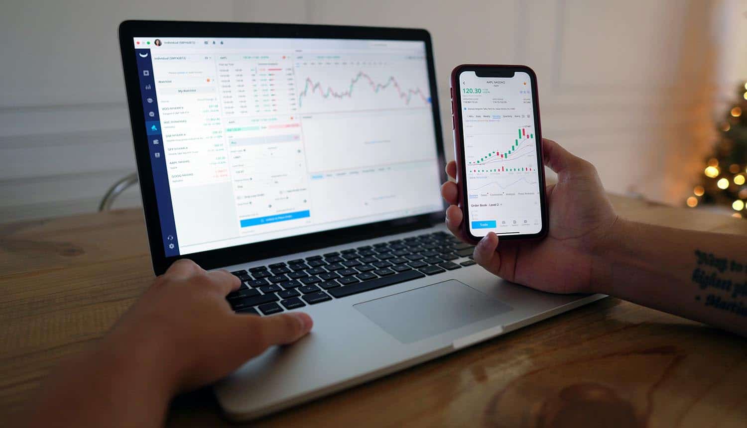Man using trading platform on laptop and mobile phone