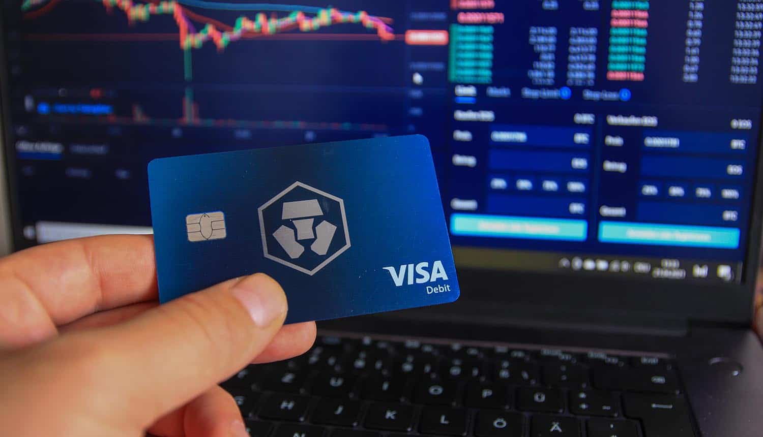 Man holding Crypto.com debit card in hand showing 2FA bypass in Crypto.com hack