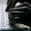 Man typing on a computer keyboard showing hacking of VirusTotal for stolen user credentials