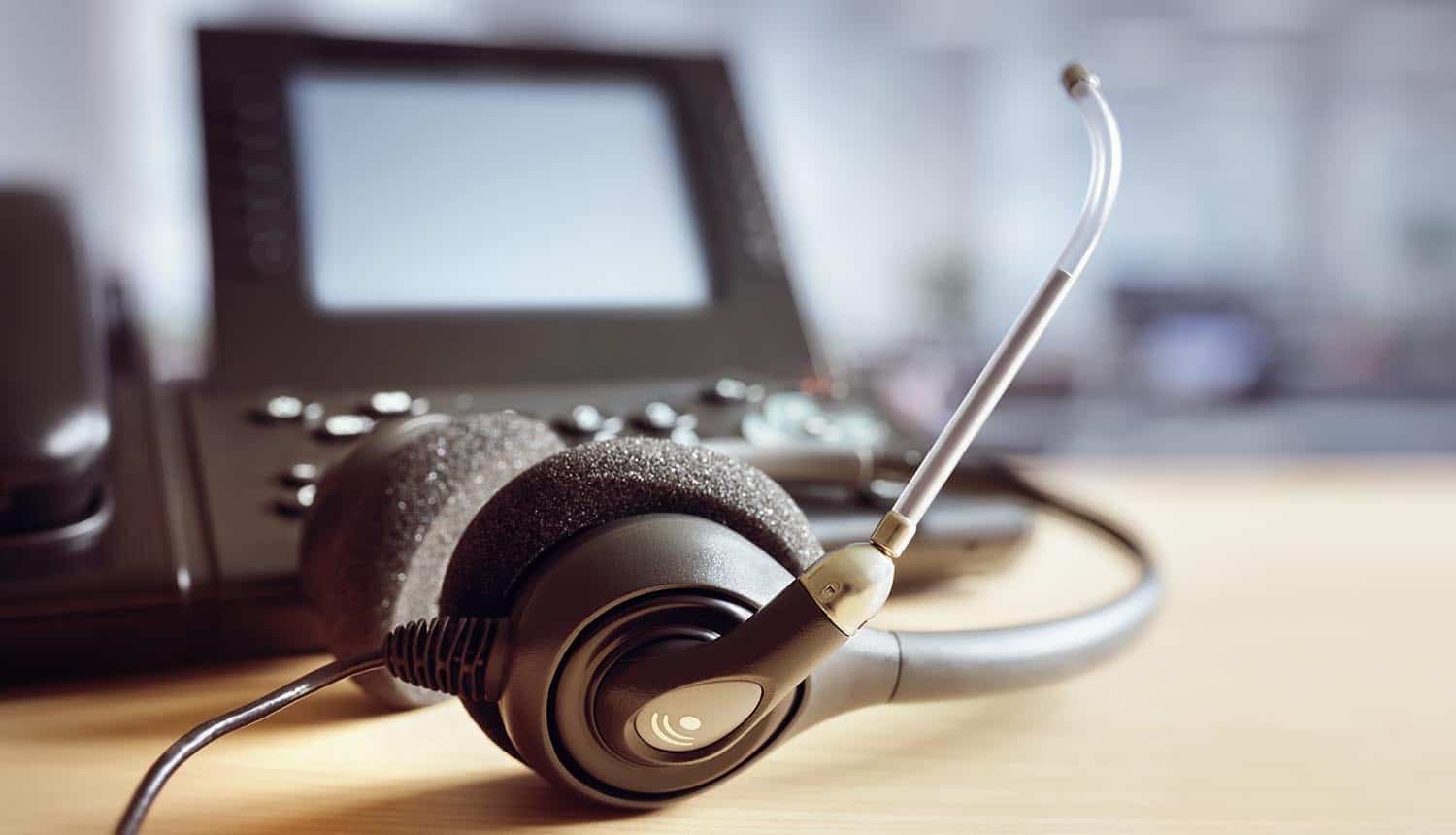 Headset and telephone on desk showing outsourcing at India call centre