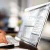Programmer at desk using laptop showing application security