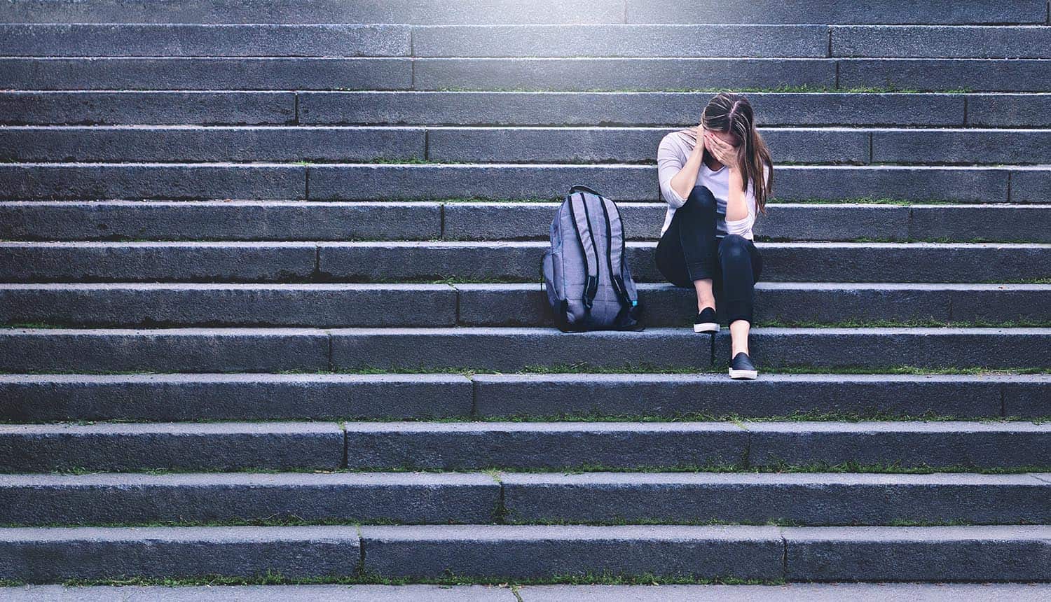 Sad teenager crying in school yard showing impact of ransomware attack