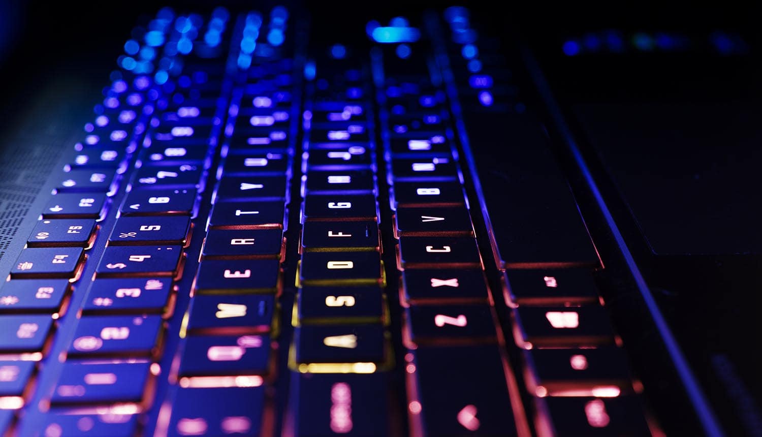 Neon computer keyboard with color backlight showing shadow code and supply chain risk