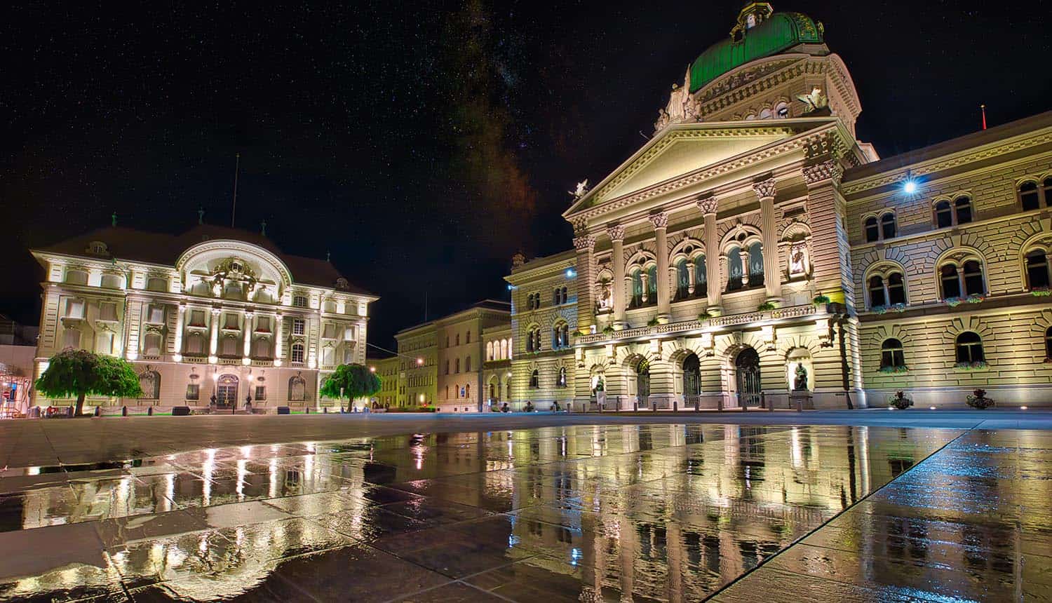 Swiss National Bank and Parliament illuminated at night showing Swiss banking secrecy