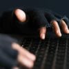 Hacker hand stealing data from laptop showing Conti ransomware