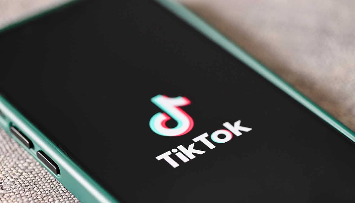 TikTok application icon on mobile phone showing privacy policy change for personalized ads