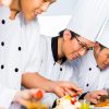 Cooks in restaurant finishing dish showing response to security incident